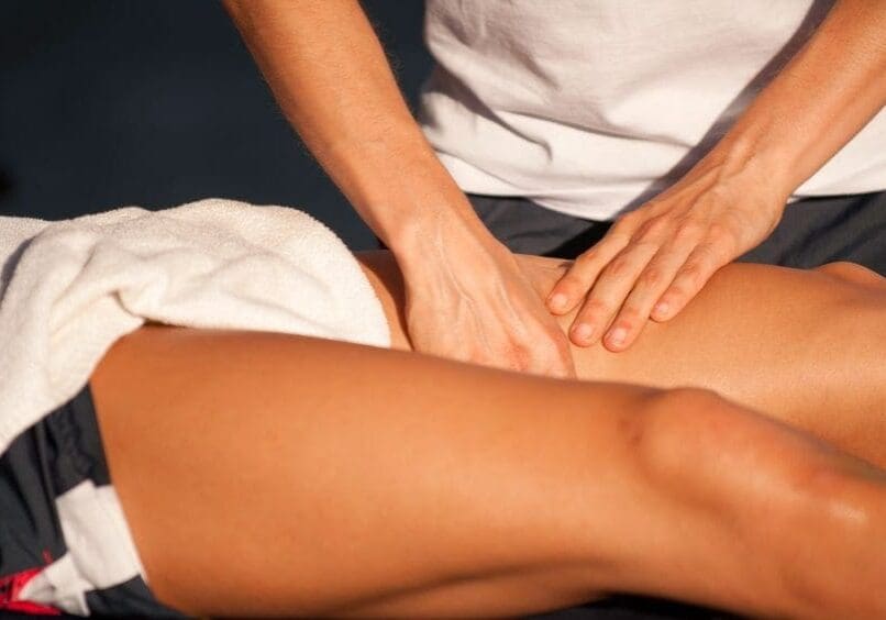 Sport therapist massaging of leg of an athlete